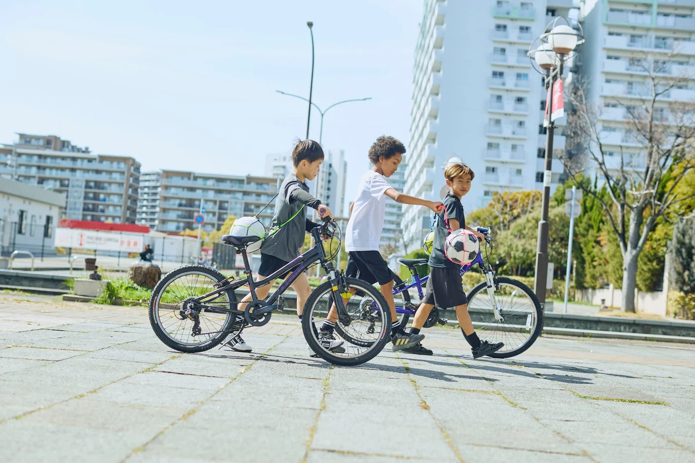 BalóNestを身につけた子どもたちが自転車と一緒に歩く様子